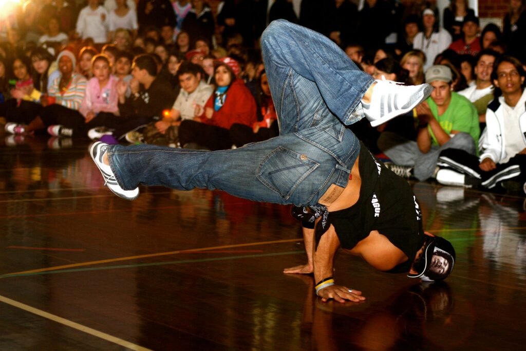 A skilled breakdancer performing a move in front of an attentive audience during a competition.